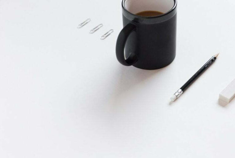 Kubek z kawą i ołówek na biurku