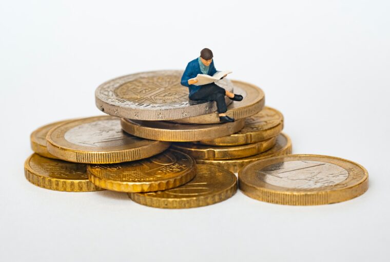 figurka człowieka siedzącego na monetach